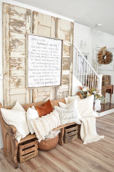 Rustic fall decor with chipped vintage doors and orange and white throw pillows