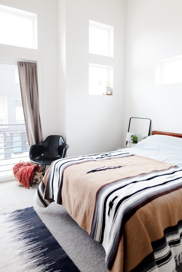 bedroom with area rug and accent chair and patterned throw on bed