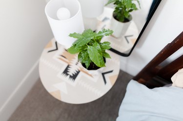 side table near with table lamp and plant near mirror