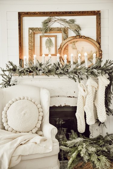 Rustic Christmas decorations on mantle with candles and winter greens