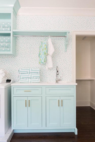 laundry room with sporty wallpaper and aqua color cupboards