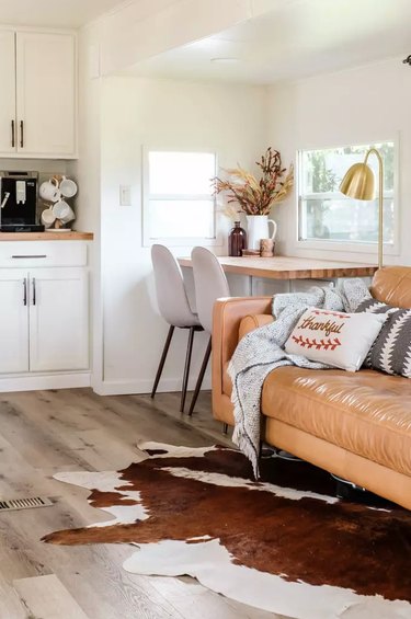 Rustic fall decor with leather couch and cowhide rug in RV