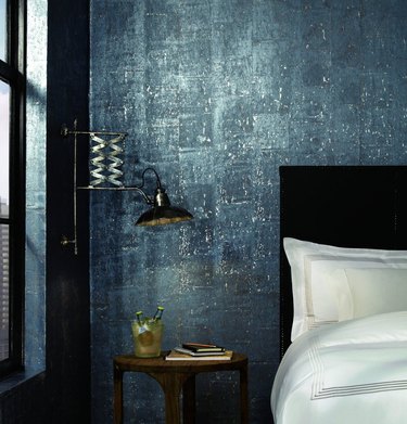 blue cork industrial wallpaper behind a bed