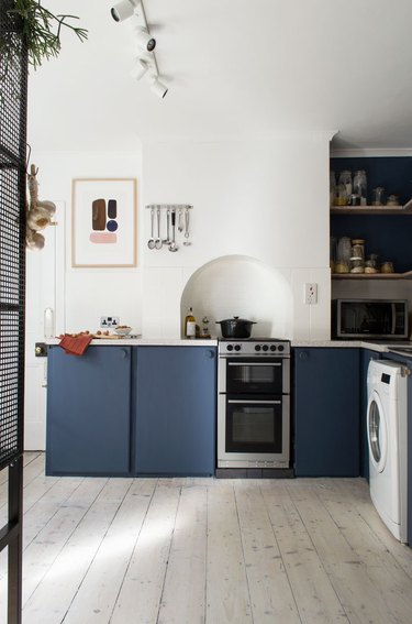 modern blue and white kitchen with flat panel cabinets and abstract artwork