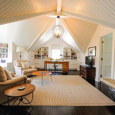 traditional attic office idea with English roll arm chairs and area rug