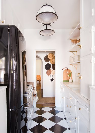 Black and white rental kitchen lighting idea with patterned flooring and white cabinets