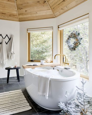 white bathroom with big tub and Christmas window decorations