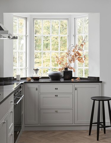 gray kitchen cabinet color with black countertops and white walls