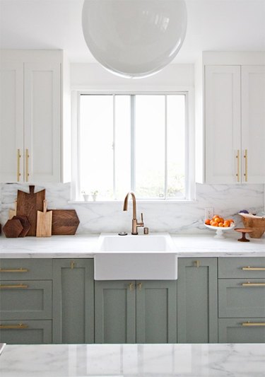 Brass hardware in a mint-and-white kitchen