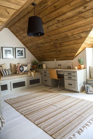 rustic attic office idea with wood ceiling and built-in seating
