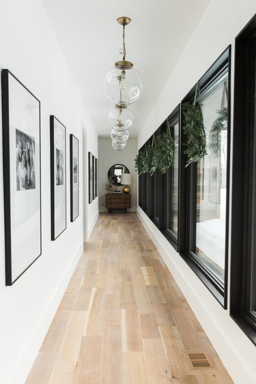 white hallway with Christmas window decorations and pendant lights