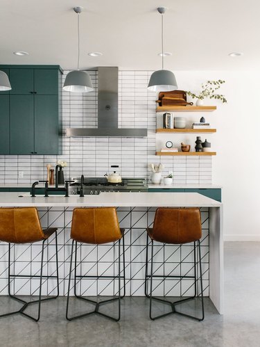 Scandinavian kitchen island ideas with seating, leather bar stools, subway tiles, and green cabinets