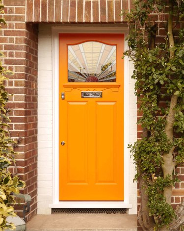 art deco stained glass in orange front door of brick exterior