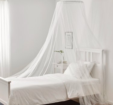 white mosquito netting over bed