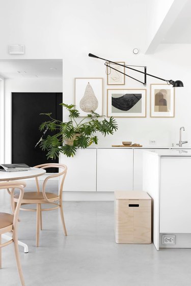 Desk lamp as alternative kitchen lighting idea with white cabinets and art gallery