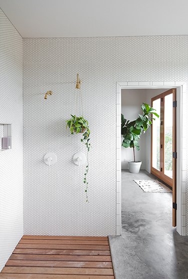 Hexagon mosaic wall tile in an open bathroom with concrete floors