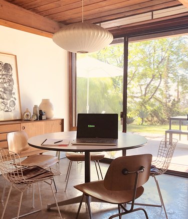 Modern dining room with laptop on table by Oonagh Ryan