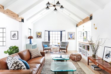 white living room layout idea with A-frame ceiling and midcentury furniture