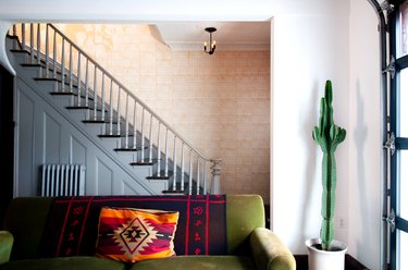 Gray painted stair rails with green couch.