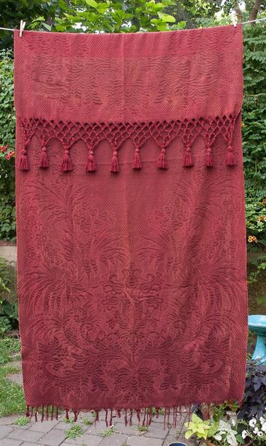 Vintage Victorian window curtain with macrame fringe.