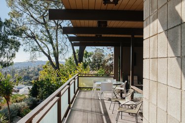 Stone for house exterior on a balcony with outdoor chairs