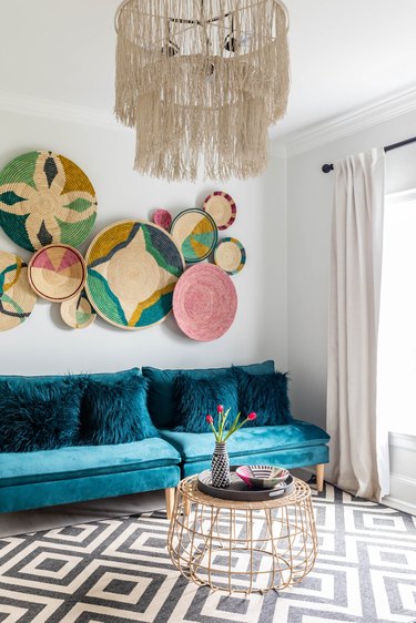 Maximalist living room with teal velvet sofa and decorative accents