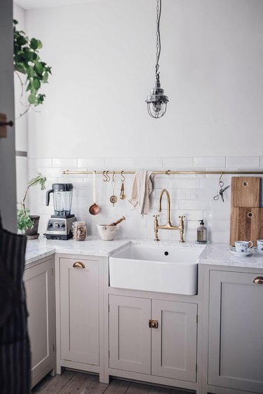 Scandinavian farmhouse kitchen with gray cabinets, white subway tile, and industrial pendant light