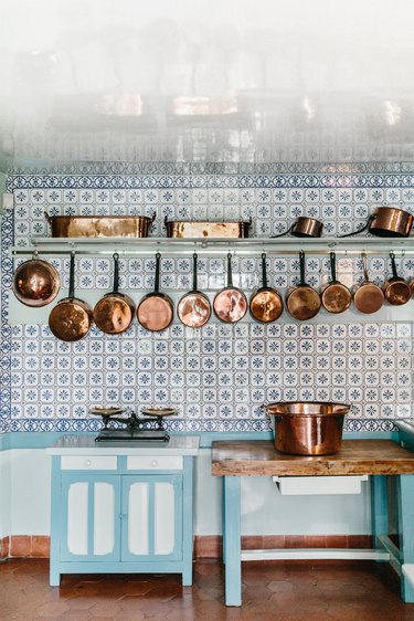 farmhouse kitchen backsplash with vintage tile and copper pans
