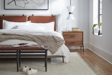 Bedroom layout idea with a bench in front of bed and pendant hanging over nightstand