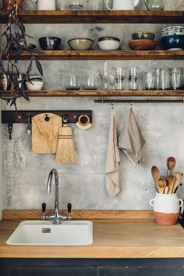 industrial kitchen with open shelving and concrete wall