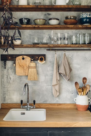 concrete effect kitchen backsplash with wood countertop and open shelving