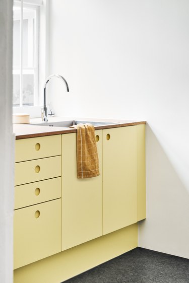 Scandinavian yellow kitchen cabinet idea with wood countertops