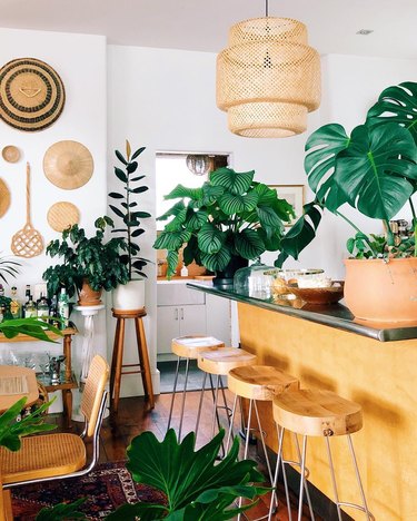 Bohemian kitchen island idea with woven pendant and plants