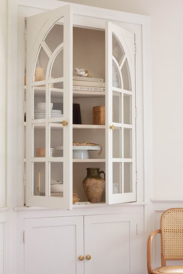 White corner cabinet with brass knobs