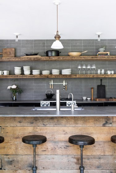 Industrial kitchen island idea with gray backsplash and gray countertops and open shelving