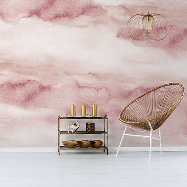 chair and shelf in front of pink watercolor wallpaper