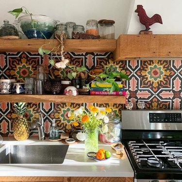 Mexican tile backsplash idea with white walls and countertop and wood shelving
