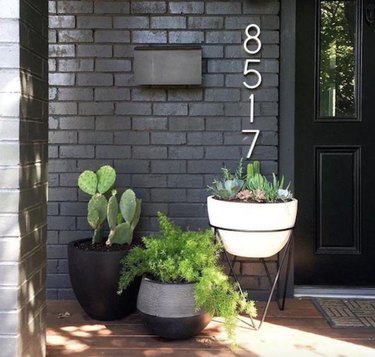 painting exterior brick and a home with cactus in planters, black brick, giant address numbers.