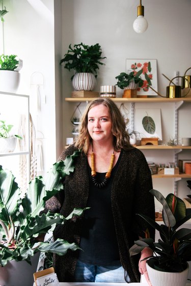 woman near shelves and plants