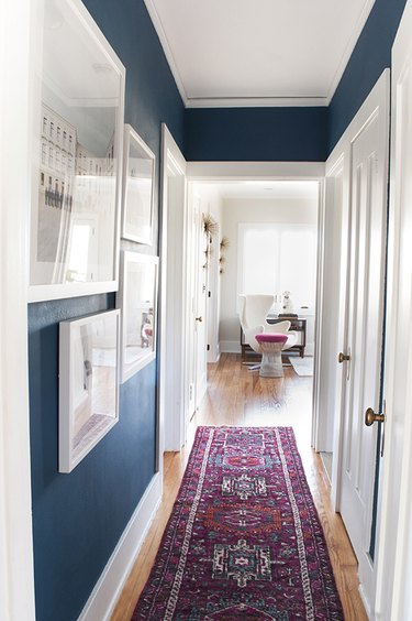 narrow hallway with area rug and gallery wall