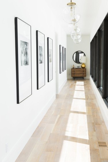 Hallway Gallery Wall Ideas with art, prints, photos, credenza, pendant lights, windows, mirror.