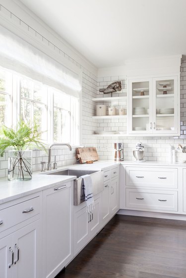 Bright white kitchen colors in kitchen with subway tile backsplash and silver faucet