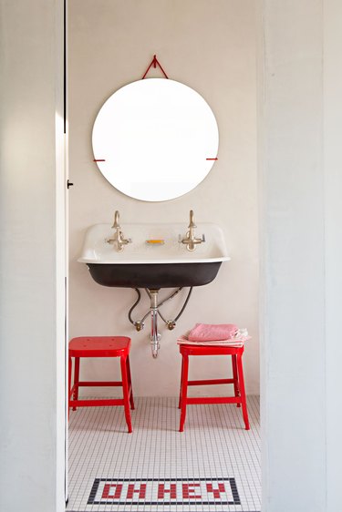 industrial bathroom with mosaic floor tile and pops of red
