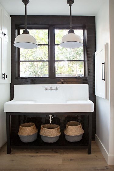 farmhouse bathroom lighting with pendants over trough sink and black tile accent wall