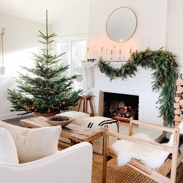 rustic Christmas tree idea with string lights in living room next to fireplace