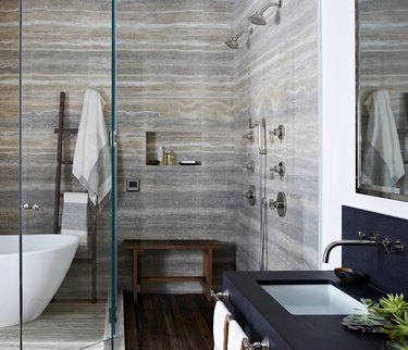 rustic shower tile in bathroom with white tub and drop-in sink