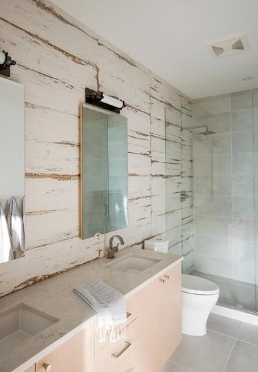 square rustic shower tile in bathroom with wood panels and wall-mounted sink