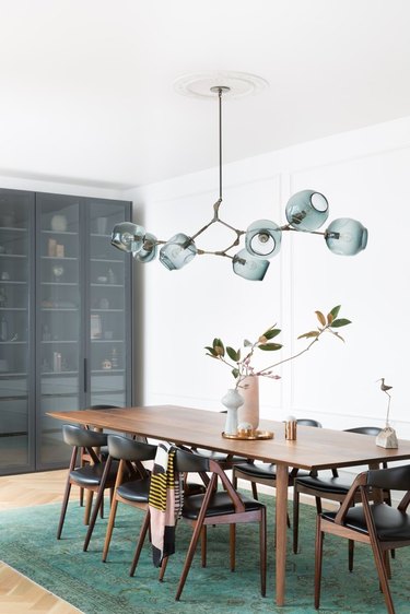 dining room with wooden table and emerald green rug