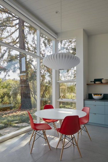 midcentury-style dining room with large windows looking out to redwoods