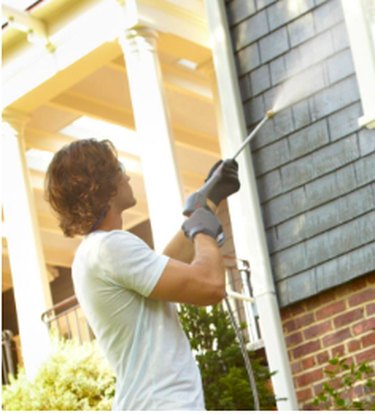 Pressure washing house siding.